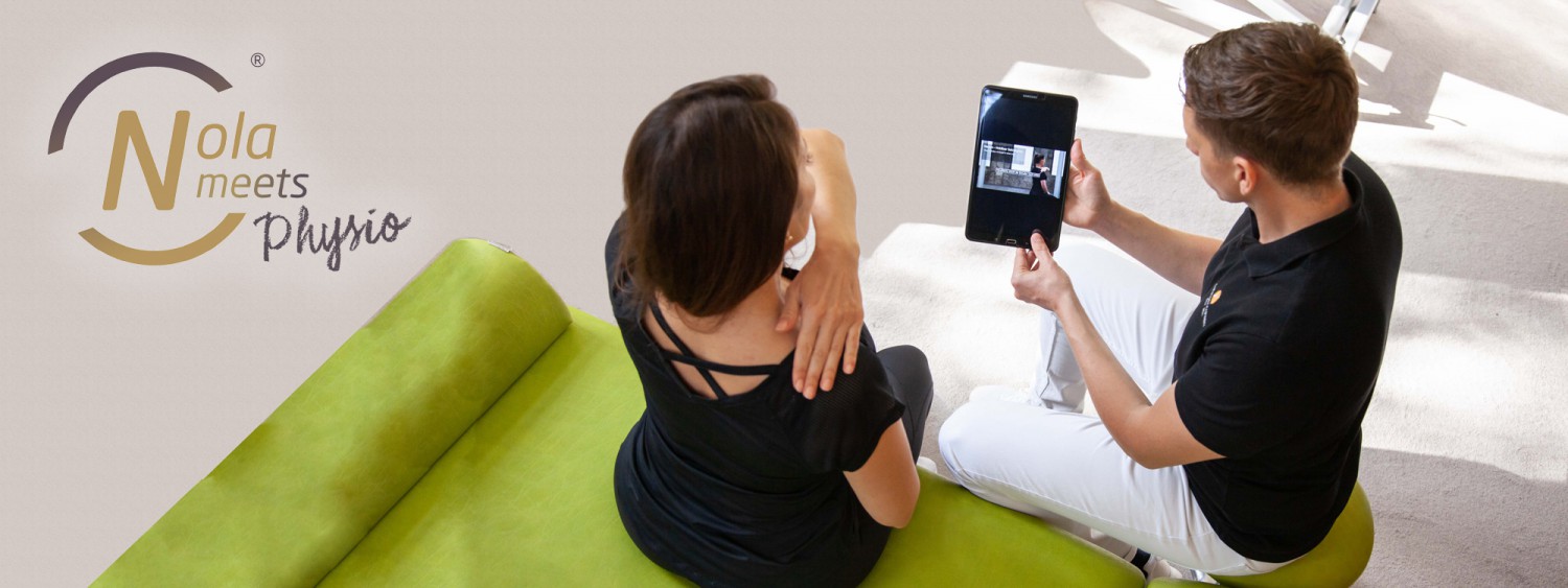 Physiotherapeut weist Patientin in Nutzung der App Nola - Your Health Coach ein